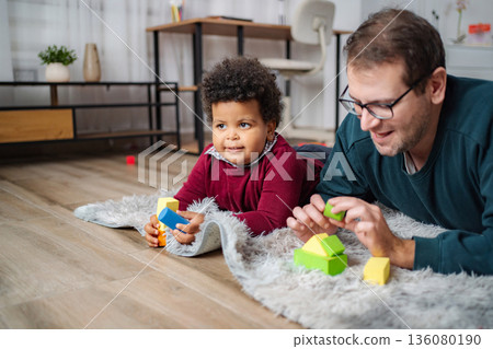 Father and son playing with colorful building blocks Father and son playing with colorful building blocks 136080190