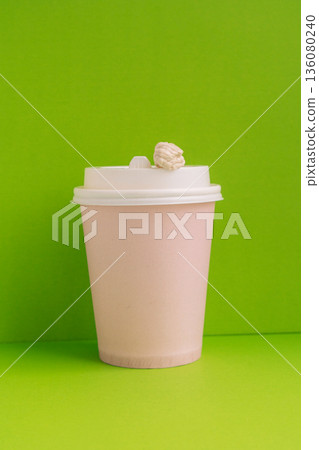 Takeaway coffee cup with chewed chewing gum on lid, green background, minimal concept Takeaway coffee cup with chewed chewing gum on lid, green background, minimal concept 136080240
