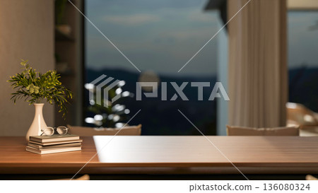 Eyeglasses over books aside plant in vase on wooden table in a living room or cafe with window wall. Eyeglasses over books aside plant in vase on wooden table in a living room or cafe with window wall. 136080324