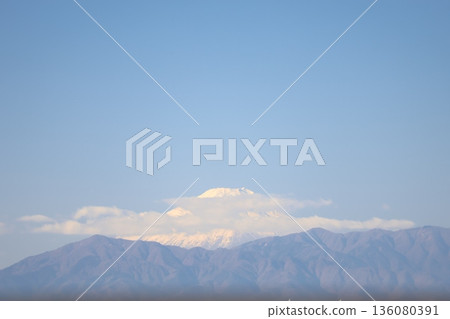 富士山白雪皚皚,藍天白雲,群山環繞,景色迷人。 富士山白雪皚皚,藍天白雲,群山環繞,景色迷人。 136080391