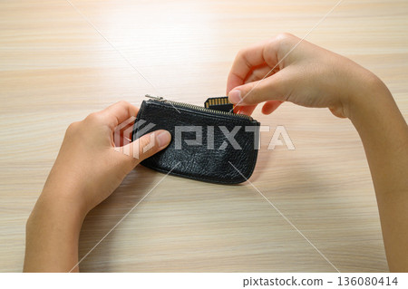 Hand storing SD card in leather pouch 136080414