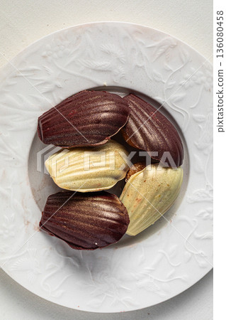 Assorted chocolate madeleine cakes on white plate 136080458