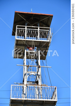 A fire lookout tower towering into the blue sky 136080481
