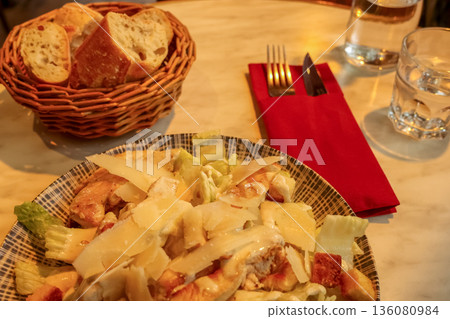 Caesar salad with chicken and parmesan cheese at a traditional Parisian bistro, enjoying travel and dining in France 136080984