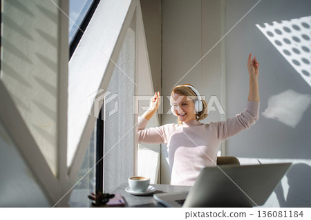 Happy woman listening to music and celebrating success Happy woman listening to music and celebrating success 136081184