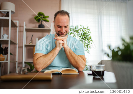 Mid adult man enjoying reading book at home 136081420