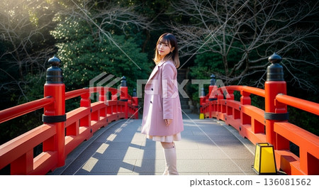 一位女子站在一座朱紅色的橋上。 136081562