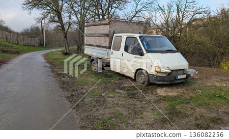 Derelict delivery van amid overcast skies and bare trees Derelict delivery van amid overcast skies and bare trees 136082256