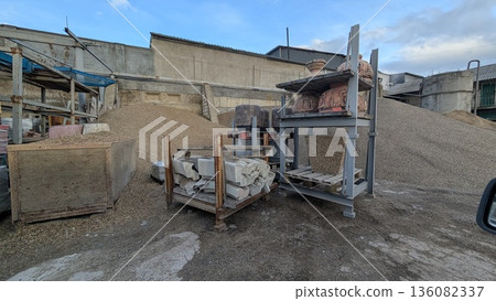 Materials for base construction placed amid muddy and factory setting Materials for base construction placed amid muddy and factory setting 136082337