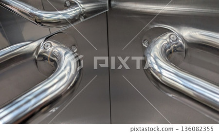 Shimmering metallic elevator pull handles with mirrorlike reflections Shimmering metallic elevator pull handles with mirrorlike reflections 136082355
