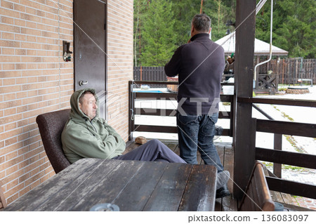Dialogue aged men in verbal dispute on home porch highlighting tension disagreement communication and relationship issues. Dialogue aged men in verbal dispute on home porch highlighting tension disagreement communication and relationship issues. 136083097