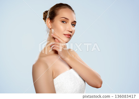 Woman posing with hand on chin in studio setting during daylight 136083417