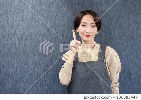 一位穿著圍裙的女店員指著 136083447