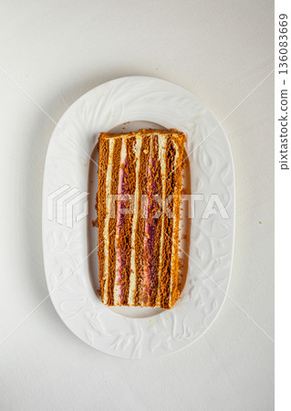 Layered cake slice with cream and berry filling Layered cake slice with cream and berry filling 136083669