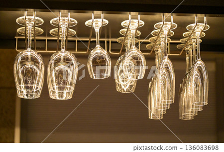 Clean wine glasses and champagne glasses hanging on the bar counter 136083698