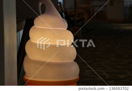 A soft serve ice cream-shaped illuminated sign emerges from the darkness A soft serve ice cream-shaped illuminated sign emerges from the darkness 136083702