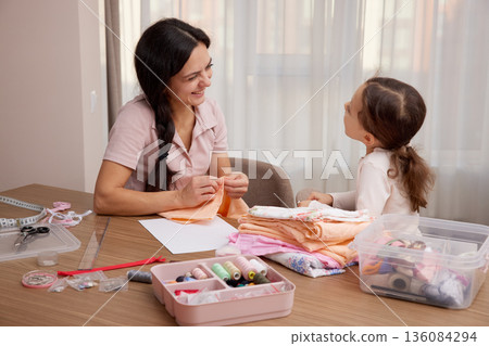 Mother and child daughter bonding, learning craft skills, and creating handmade items 136084294