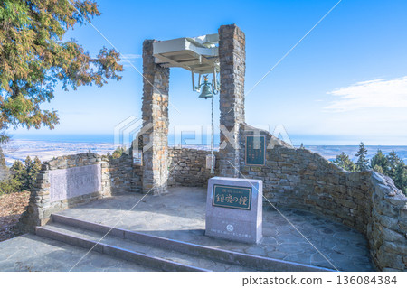 A prayer scene on the mountaintop with a deep mountain requiem bell and a distant view of the Pacific Ocean 136084384