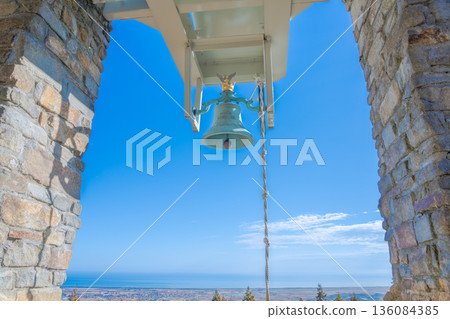 The deep mountain requiem bell rings out into the blue sky; a symbol of prayer overlooking the sea 136084385