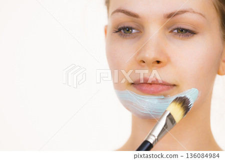 Girl apply green mud mask to face 136084984