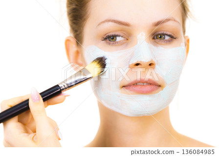 Girl apply green mud mask to face Girl apply green mud mask to face 136084985