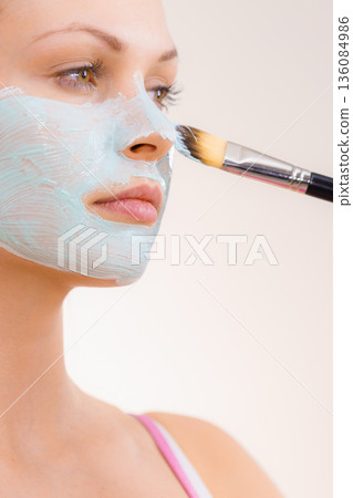 Girl apply green mud mask to face 136084986