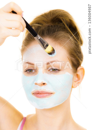 Girl apply green mud mask to face 136084987