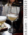 Pouring champagne into a glass at a celebration 136085619