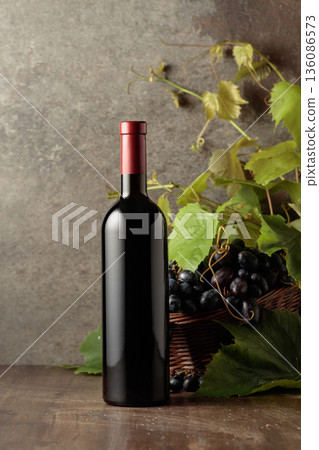 Bottle of red wine with blue grapes and vine branches. Bottle of red wine with blue grapes and vine branches. 136086573