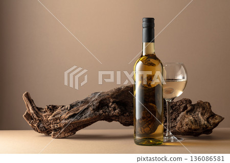 White wine and old snag on a beige background. 136086581