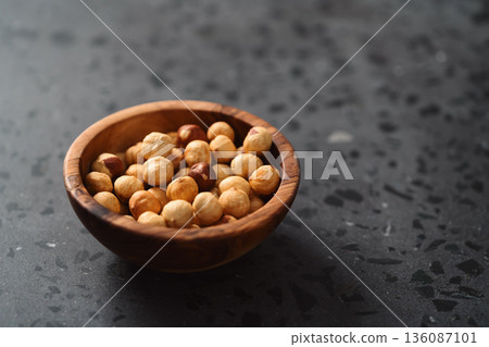 roasted hazelnuts in olive bowl on terrazzo countertop roasted hazelnuts in olive bowl on terrazzo countertop 136087101