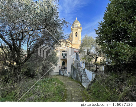 View of church and olive trees from mountain. Nature, traditional town, buildings of Liguria. Architecture and structures in Italy. Points of interest along hiking route in Sestri Levante. View of church and olive trees from mountain. Nature, traditional town, buildings of Liguria. Architecture and structures in Italy. Points of interest along hiking route in Sestri Levante. 136087126