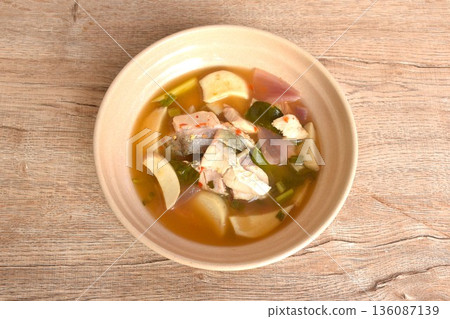 boiled bass fish meat and mushroom in clear tom yum Thai herb soup on plate boiled bass fish meat and mushroom in clear tom yum Thai herb soup on plate 136087139