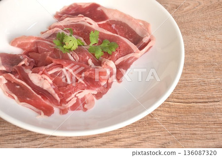 slice brisket beef raw food topping parslty arrangig in plate on table slice brisket beef raw food topping parslty arrangig in plate on table 136087320