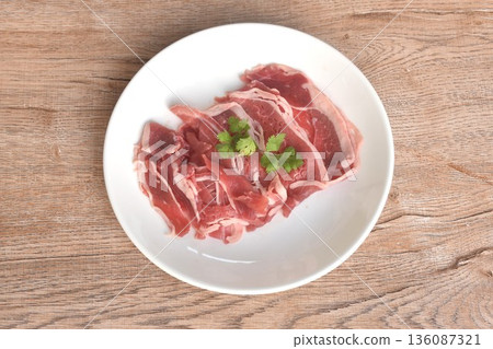 slice brisket beef raw food topping parslty arrangig in plate on table slice brisket beef raw food topping parslty arrangig in plate on table 136087321