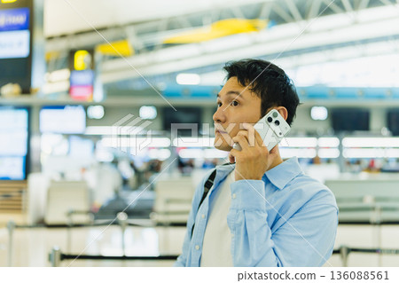 一名男子在機場使用手機通話。照片由關西國際機場（KIX）提供。 136088561
