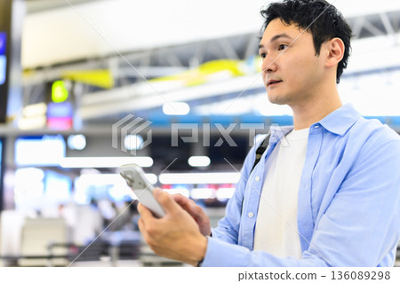 A man using a smartphone at the airport. Photo courtesy of Kansai International Airport (KIX) A man using a smartphone at the airport. Photo courtesy of Kansai International Airport (KIX) 136089298