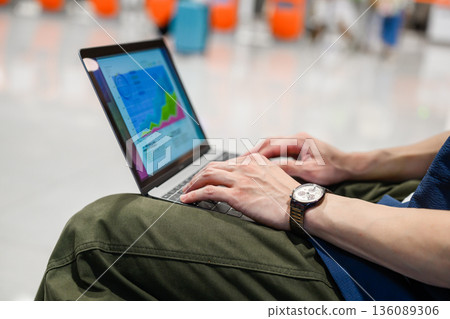 A man working on a PC at the airport. Photo courtesy of Kansai International Airport (KIX). 136089306