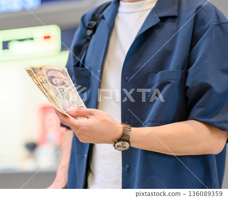 A man counts Japanese yen. Photo courtesy of Kansai International Airport (KIX) A man counts Japanese yen. Photo courtesy of Kansai International Airport (KIX) 136089359