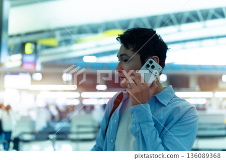 A man making a phone call at the airport. Photo courtesy of Kansai International Airport (KIX) 136089368