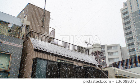 Heavy snow falls in a city crowded with buildings Heavy snow falls in a city crowded with buildings 136089373