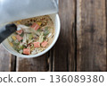 Pouring hot water into seafood-flavored instant ramen 136089380