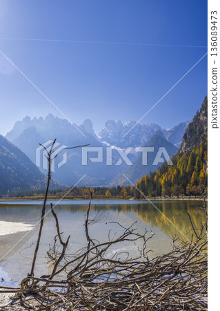 Lago di Dobbiaco with autumn trees and Dolomite mountains Lago di Dobbiaco with autumn trees and Dolomite mountains 136089473