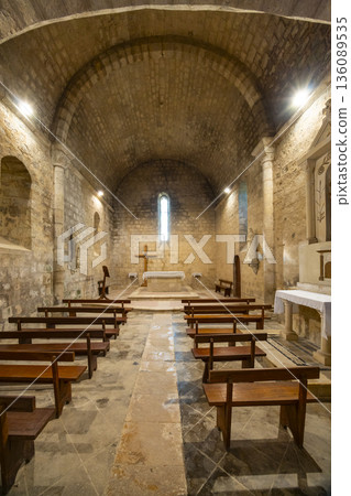 Church interior with stone walls, altar, and pews in Larressingle Church interior with stone walls, altar, and pews in Larressingle 136089535