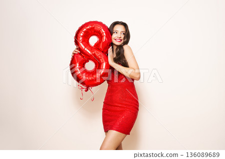 Beauty woman in a festive dress hold balloon number 8 Beauty woman in a festive dress hold balloon number 8 136089689