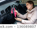 An adult woman is cleaning her car 136089807