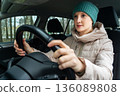 A woman is sitting in a car 136089808