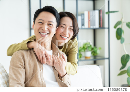 A middle-aged couple having a good time in the living room 136089878