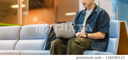 A man working on a PC at the airport. Photo courtesy of Kansai International Airport (KIX). 136090121