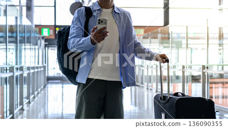 A man using a smartphone at the airport. Photo courtesy of Kansai International Airport (KIX) A man using a smartphone at the airport. Photo courtesy of Kansai International Airport (KIX) 136090355
